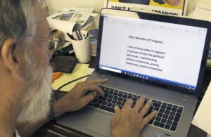 a man on a laptop writing a member of congress