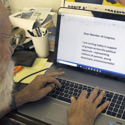 a man on a laptop writing a member of congress